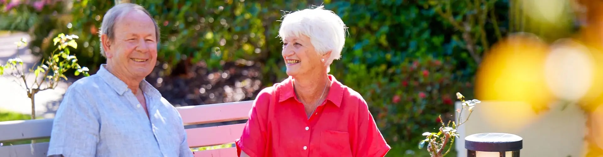 Happy older couple in a beautiful garden setting at a Ryman retirement village.