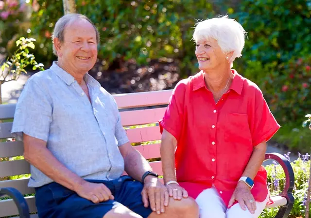 Happy older couple in a beautiful garden setting at a Ryman retirement village.